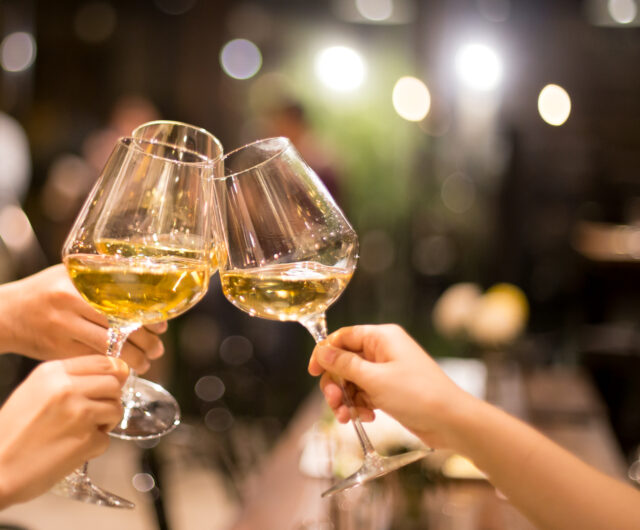 Shot in high iso with low light group of friend toasting with wi